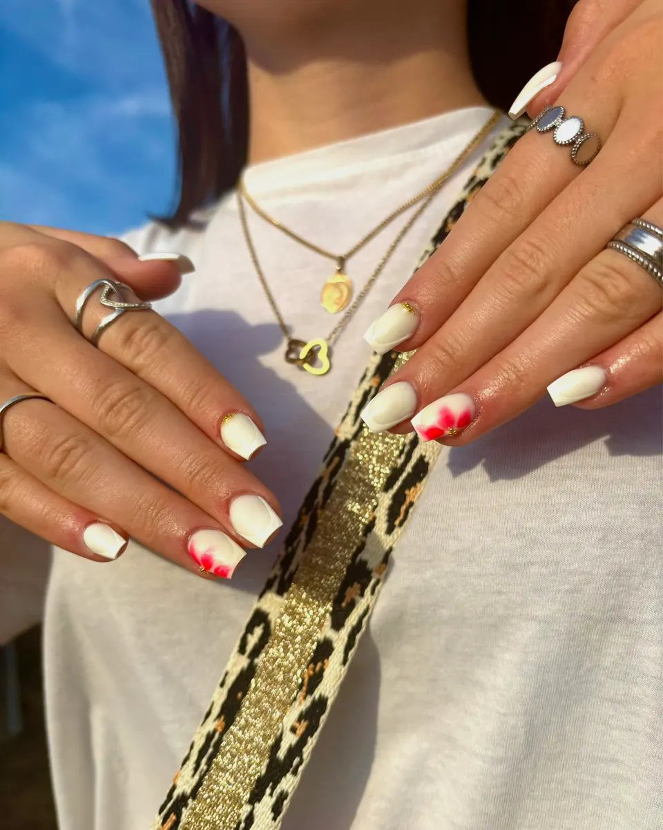 Ongles carrés blanc crème à double french, ornés d’une fleur rouge aquarelle et de caviar doré