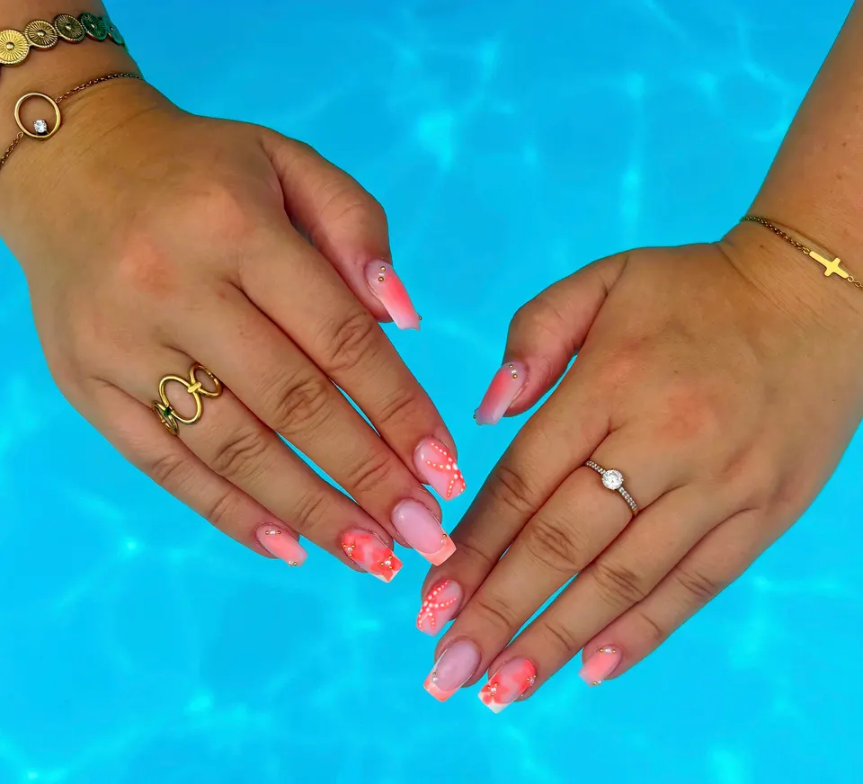 Pose carrée rose et corail avec détails dorés, photographiée au bord d’une piscine