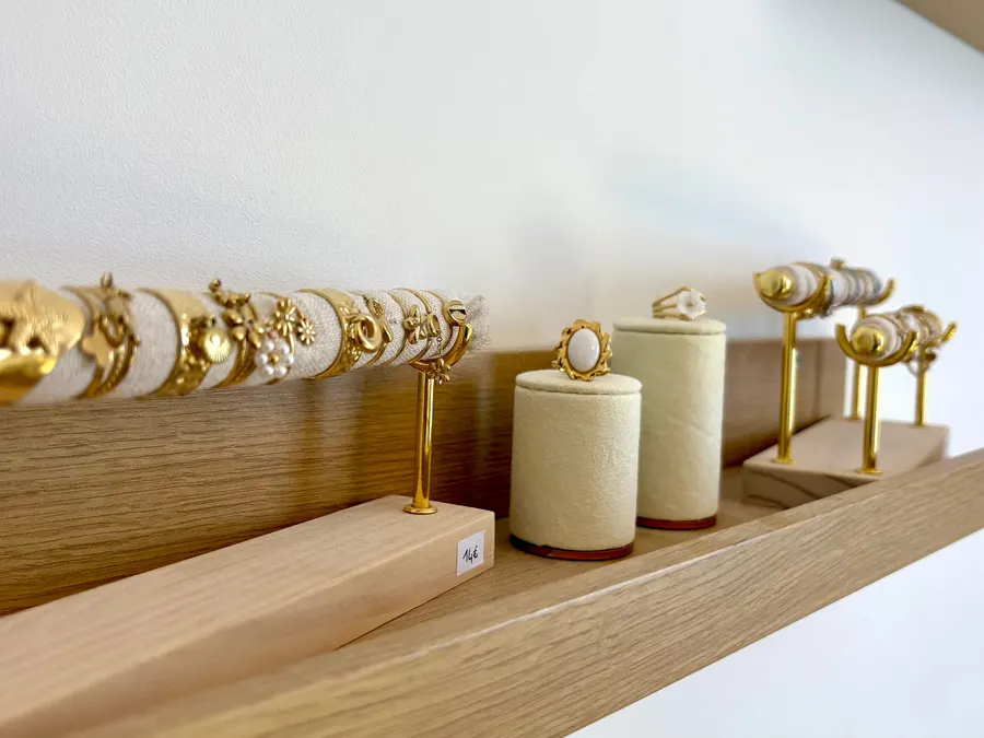 Présentoir de bijoux dorés sur une étagère en bois clair de l’Institut Solaïa